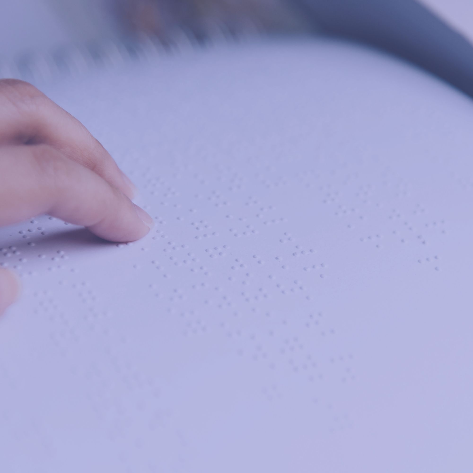Doigts lisant un texte en braille.