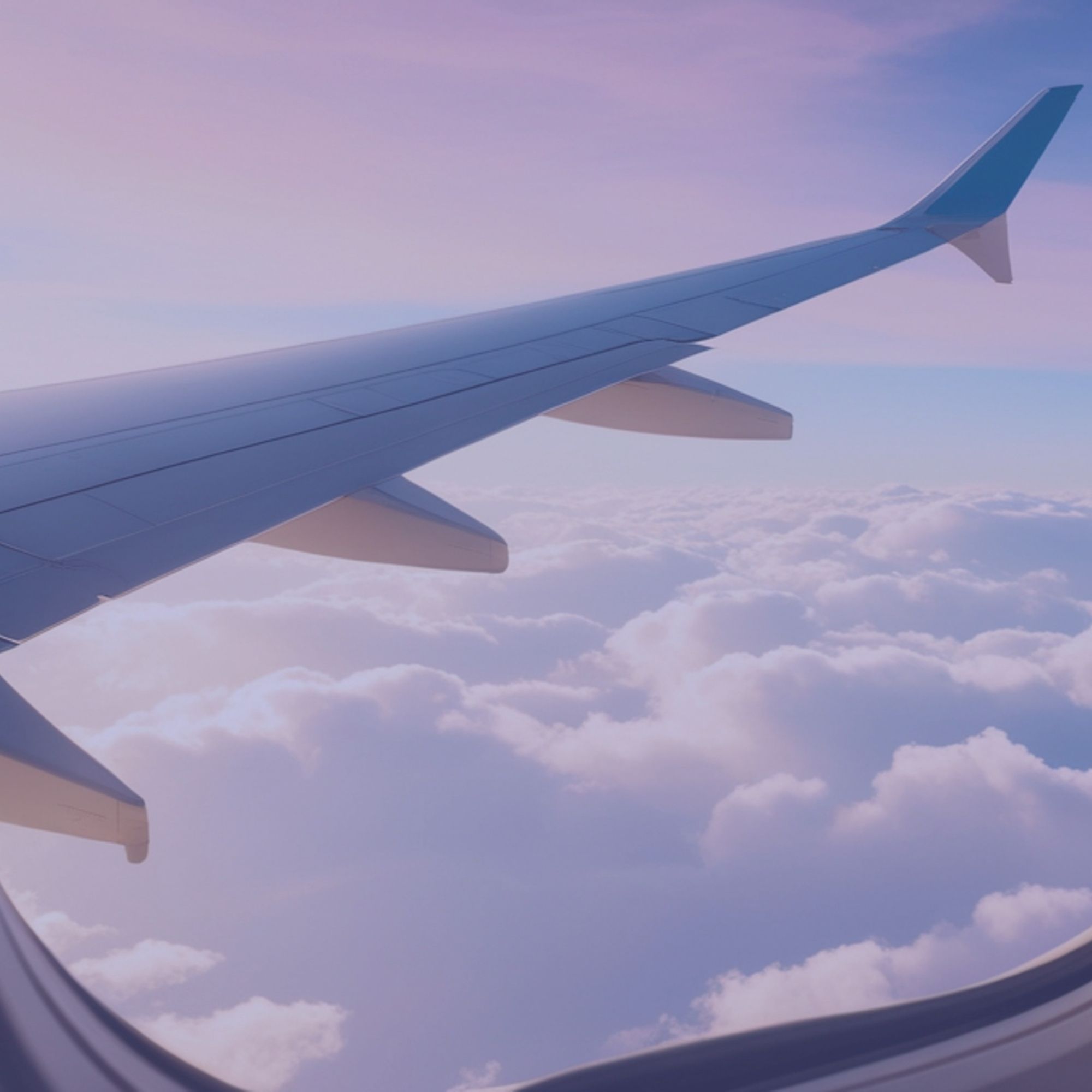 Aile d'avion vue à travers un hublot, au-dessus des nuages.