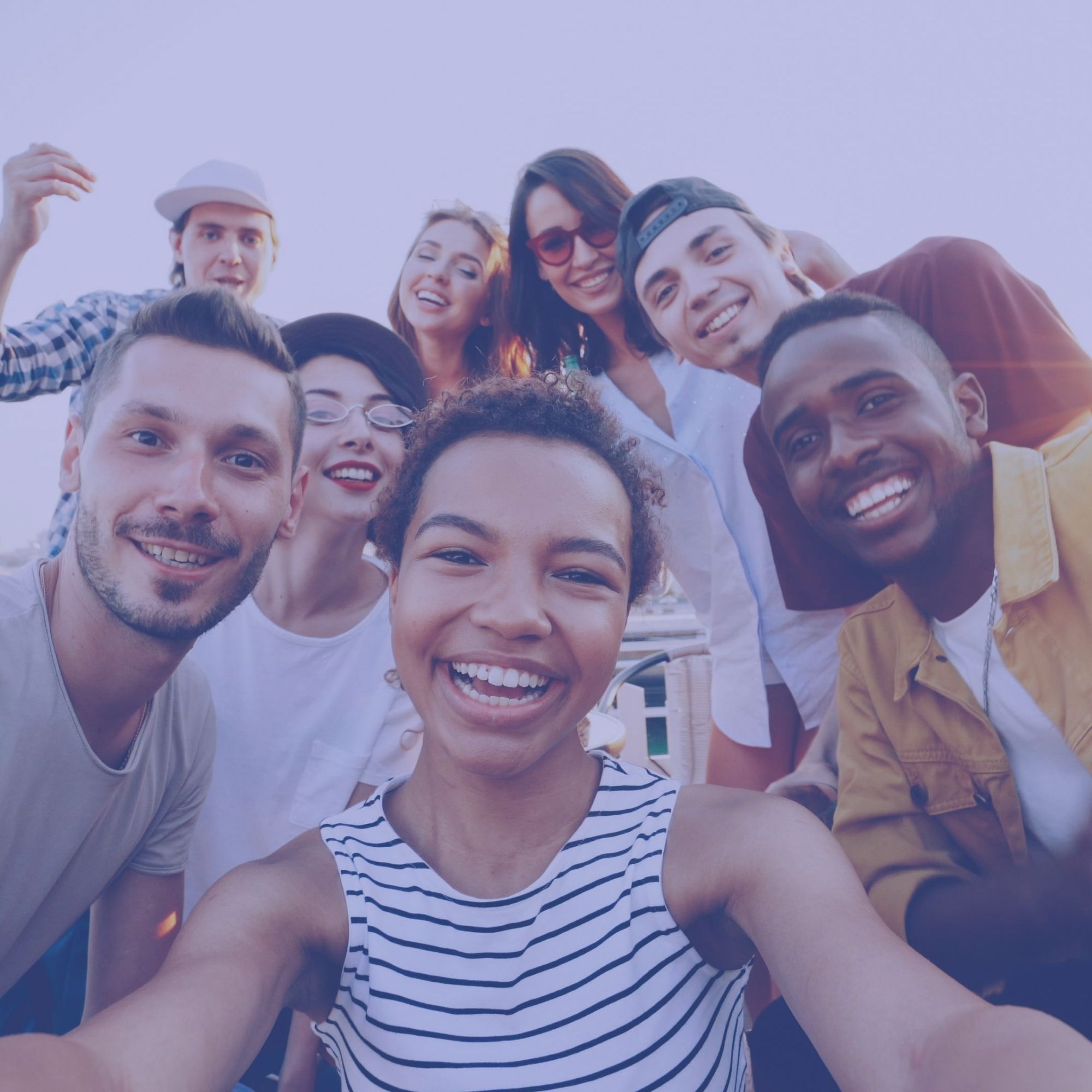 Groupe de huit étudiants souriants qui prennent un selfie en extérieur