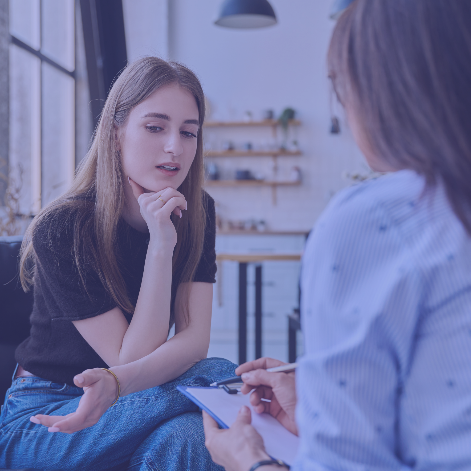 Deux jeunes femmes en entretien, l'une prenant des notes sur un bloc.